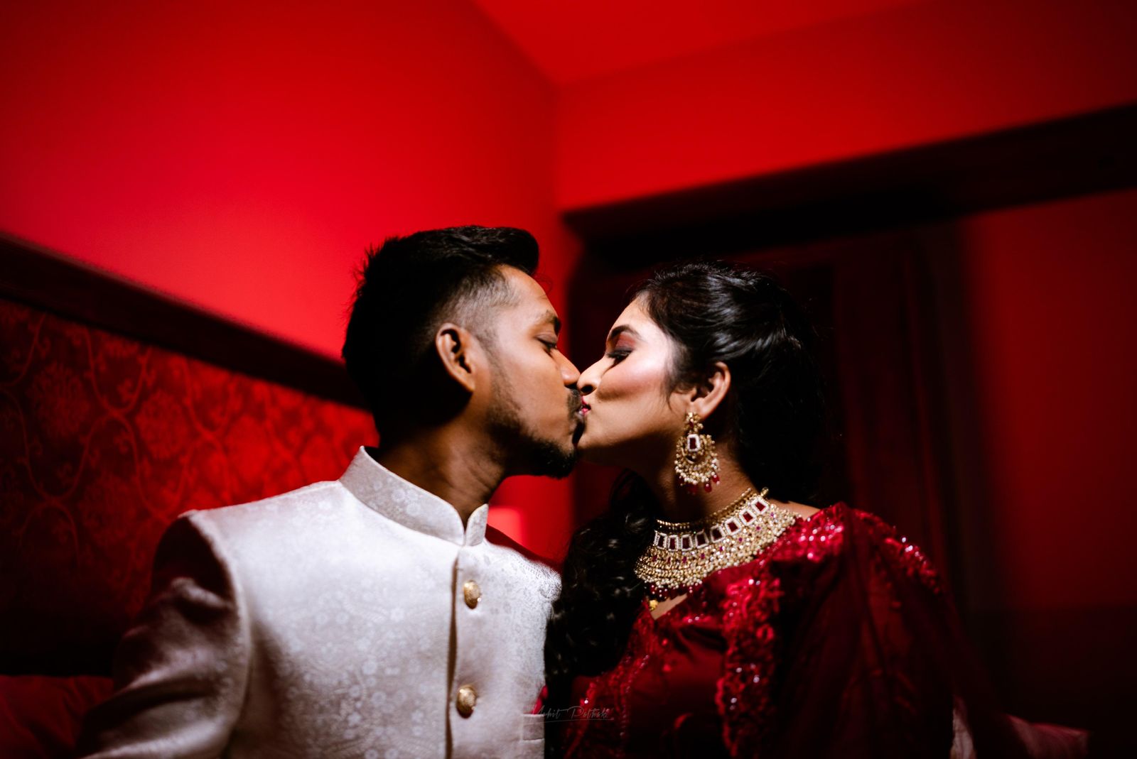 Couple kiss in warm red room light