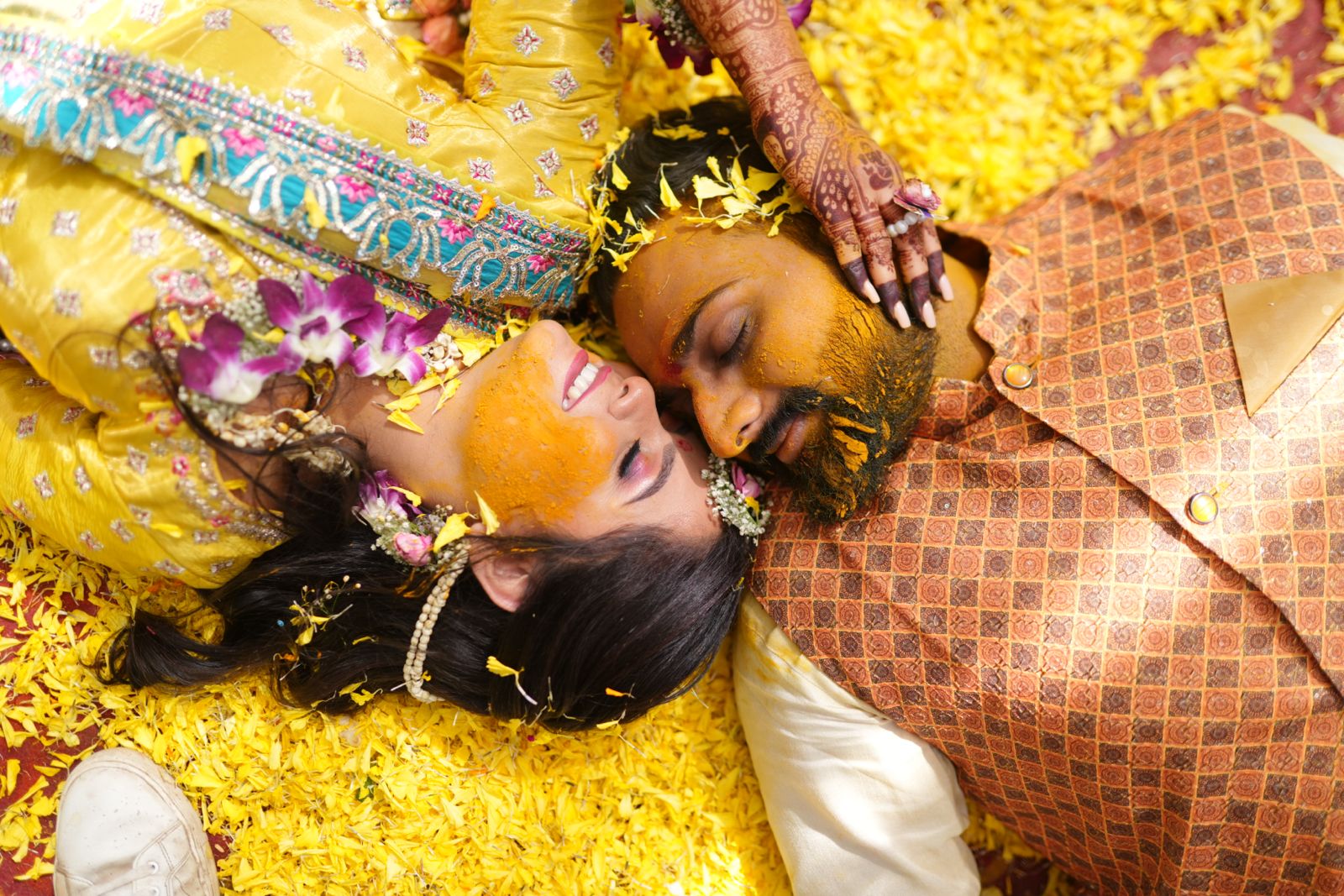 Haldi ceremony portrait on a bed of yellow petals